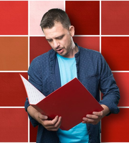 Young man wearing a blue outfit. Holding a red folder.