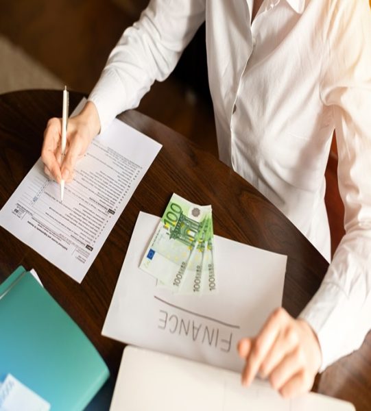 Woman working with finances on the table. Money, papers